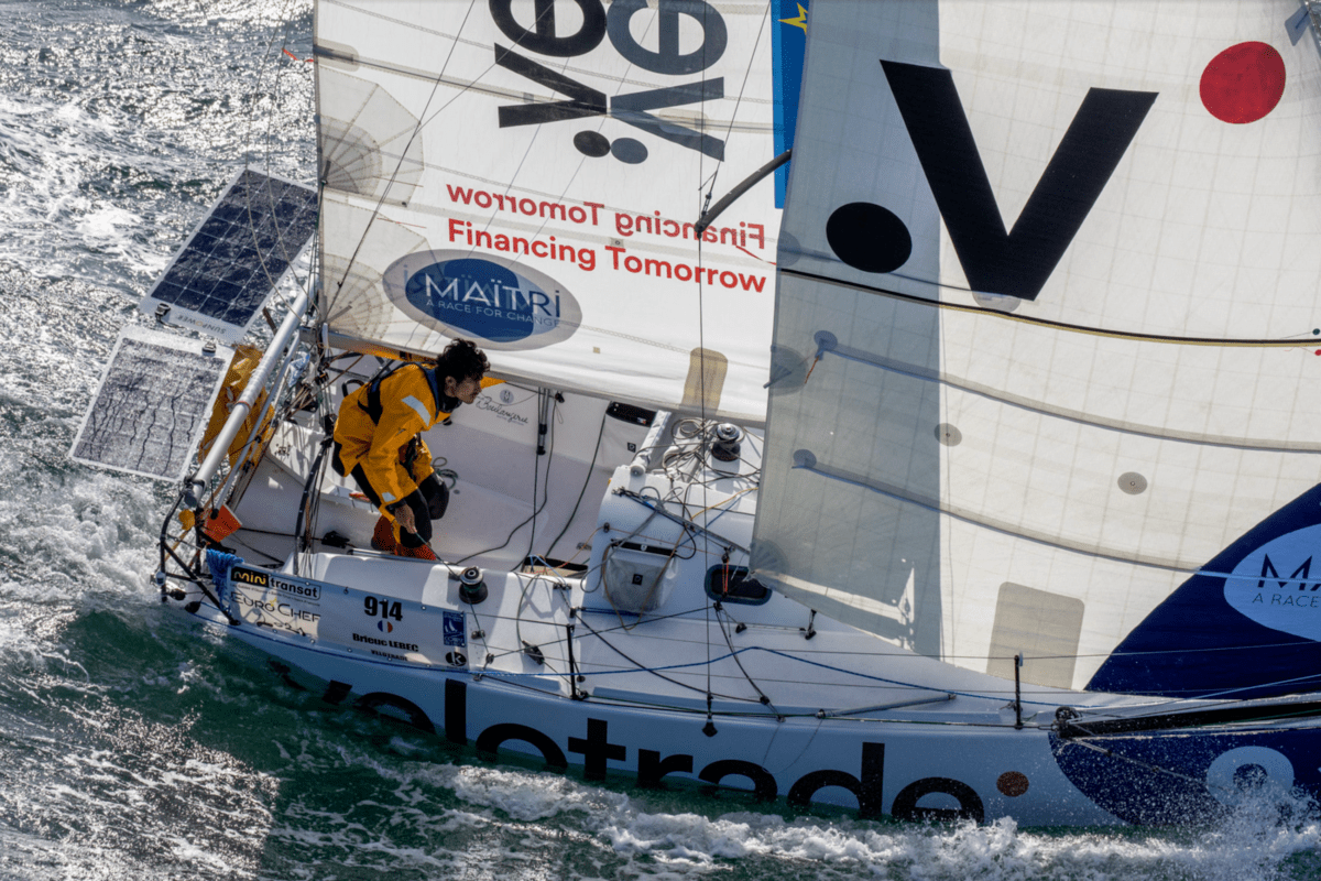 Top angle shot of the Velotrade sailboat with the skipper in action while manoeuvring ahead in rough seas.