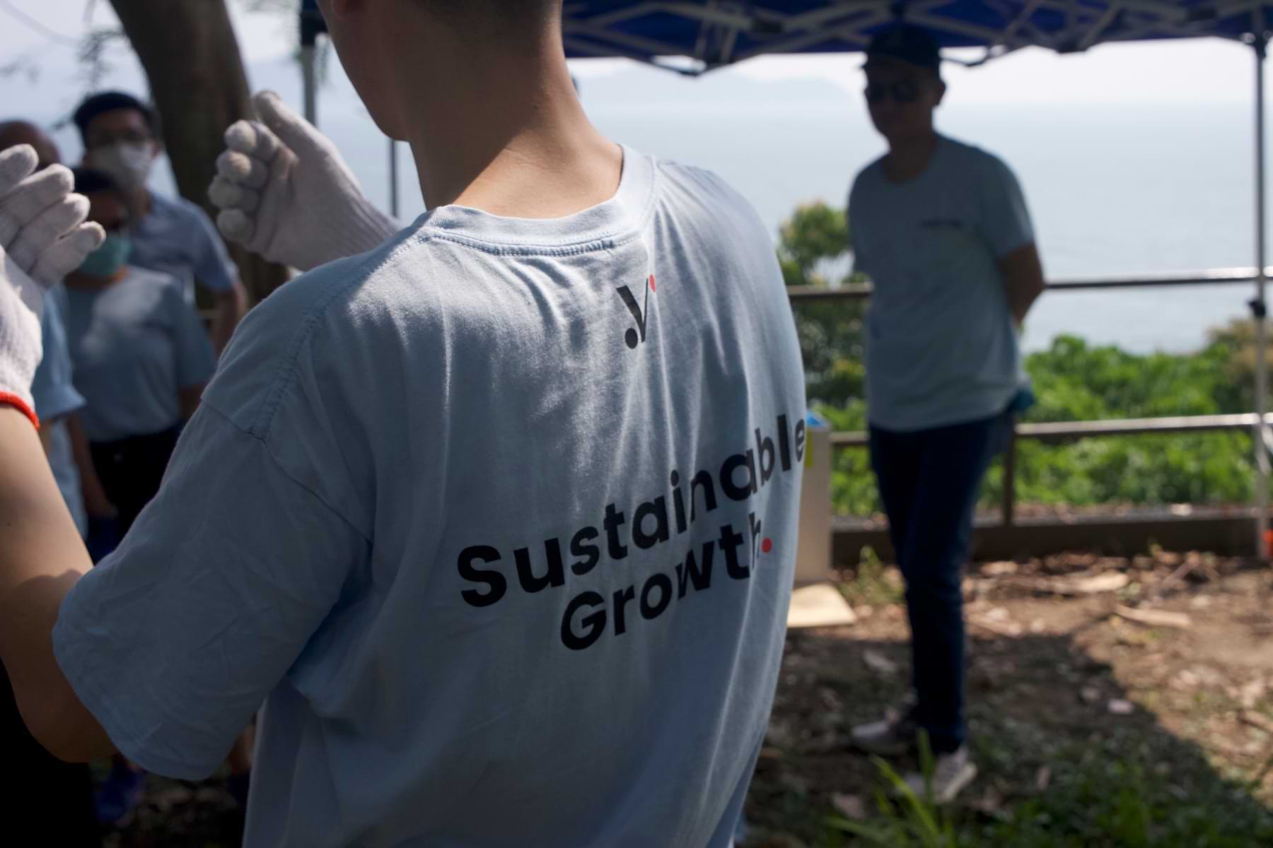 Close-up shot of Velotrade team member wearing a tee with logo and tagline "Sustainable Growth".